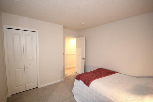 bedroom with a closet and light colored carpet