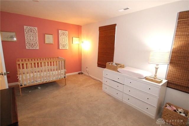 carpeted bedroom featuring a crib