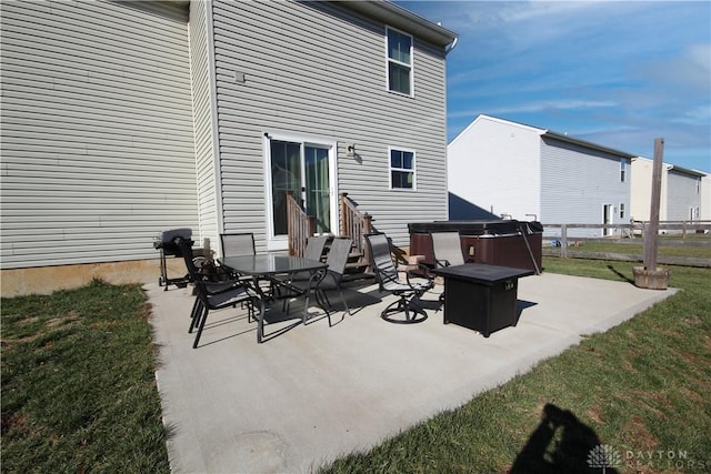 rear view of property with a yard, a patio, and a fire pit