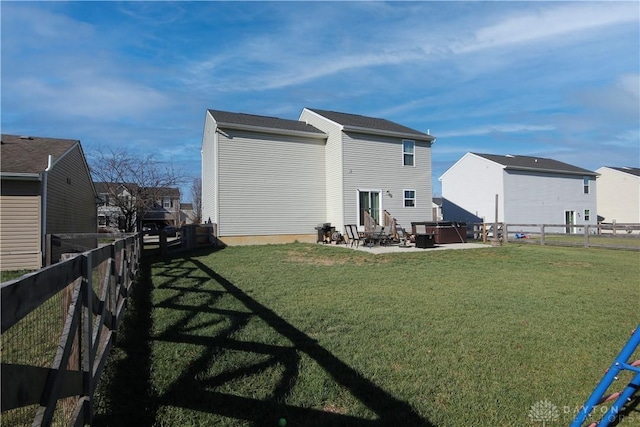 rear view of house with a lawn and a patio