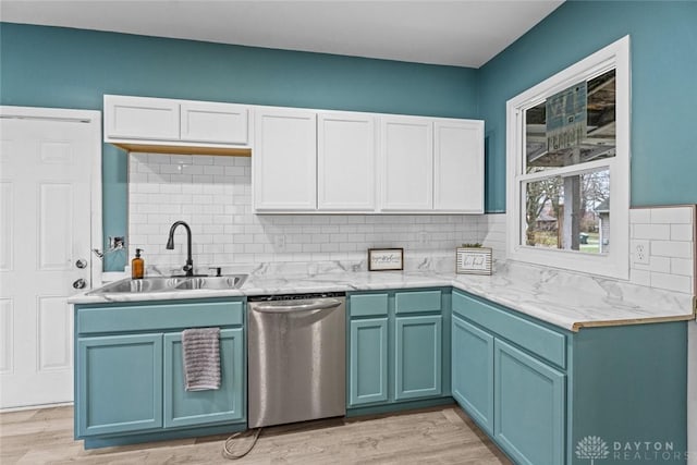 kitchen with dishwasher, sink, blue cabinets, decorative backsplash, and light wood-type flooring