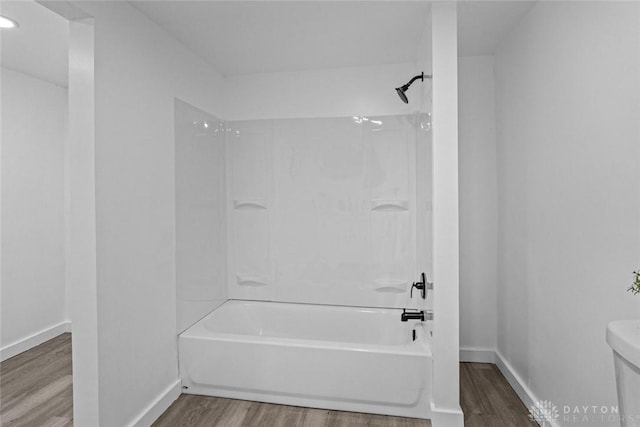 bathroom featuring toilet, tub / shower combination, and hardwood / wood-style flooring