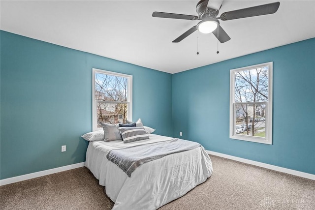 carpeted bedroom featuring multiple windows and ceiling fan