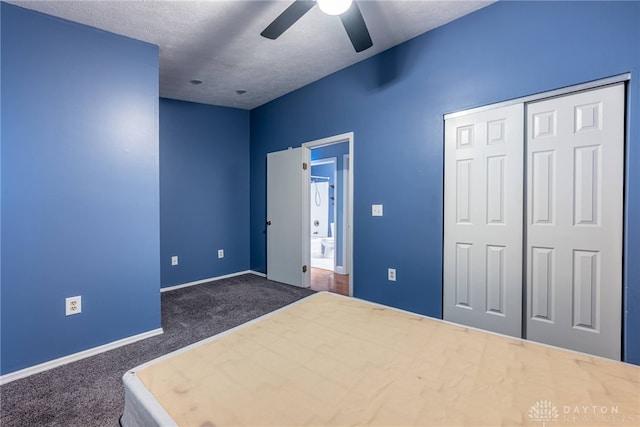 unfurnished bedroom with ceiling fan, a closet, dark carpet, and a textured ceiling