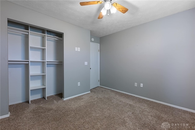 unfurnished bedroom featuring ceiling fan, a closet, carpet, and a textured ceiling