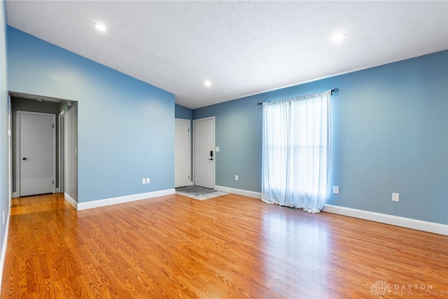 empty room featuring light hardwood / wood-style flooring and vaulted ceiling