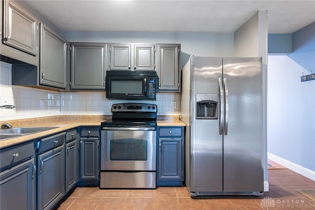 kitchen featuring decorative backsplash, sink, light tile patterned flooring, and stainless steel appliances