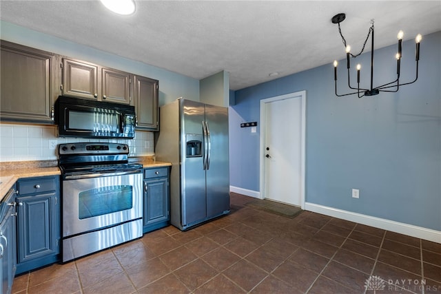 kitchen with dark tile patterned floors, stainless steel appliances, and tasteful backsplash