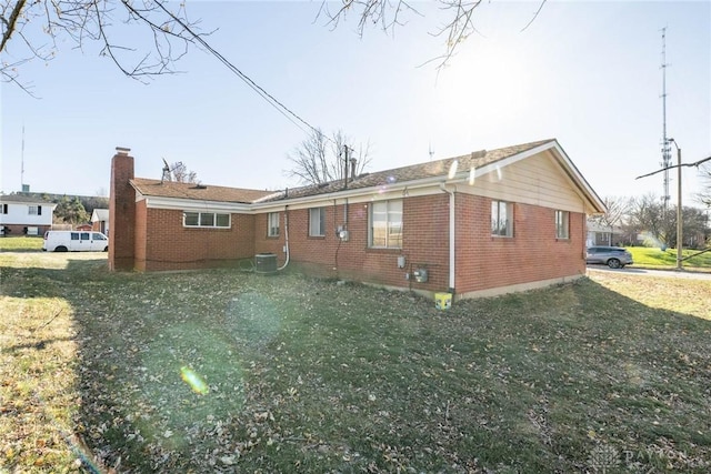 view of property exterior with a lawn and cooling unit