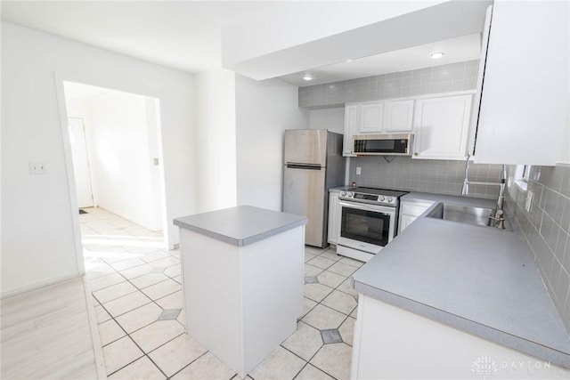 kitchen with light tile patterned flooring, sink, white cabinets, and stainless steel appliances