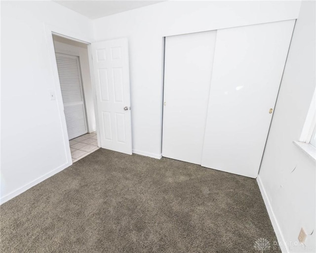 unfurnished bedroom featuring a closet and light colored carpet