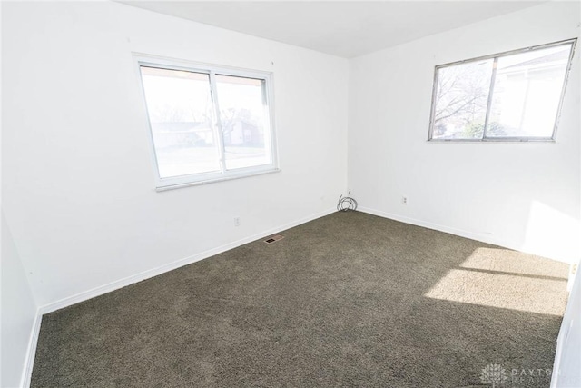 unfurnished room featuring dark carpet