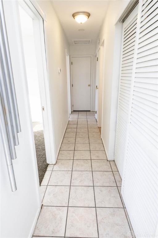 hall featuring light tile patterned floors