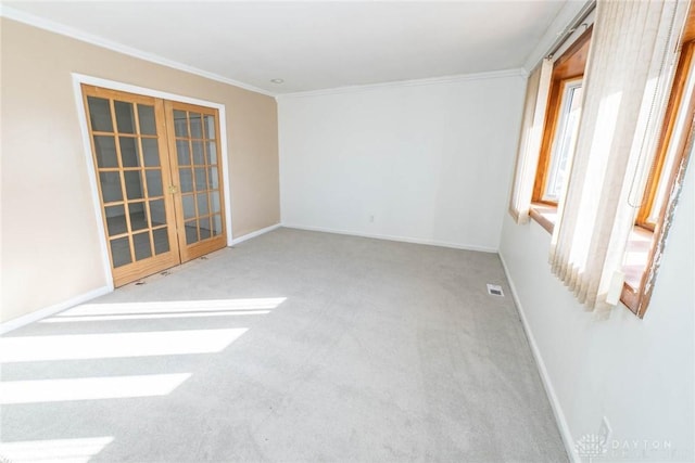 empty room featuring french doors, carpet, and ornamental molding