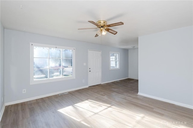 interior space featuring baseboards, wood finished floors, visible vents, and ceiling fan