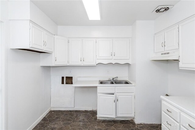 kitchen featuring sink and white cabinets