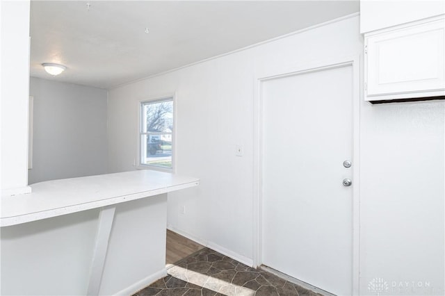 interior space with light countertops, white cabinets, and baseboards