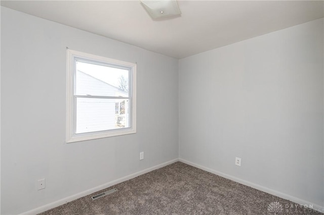 carpeted spare room featuring visible vents and baseboards