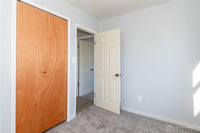 unfurnished bedroom featuring a closet and light carpet