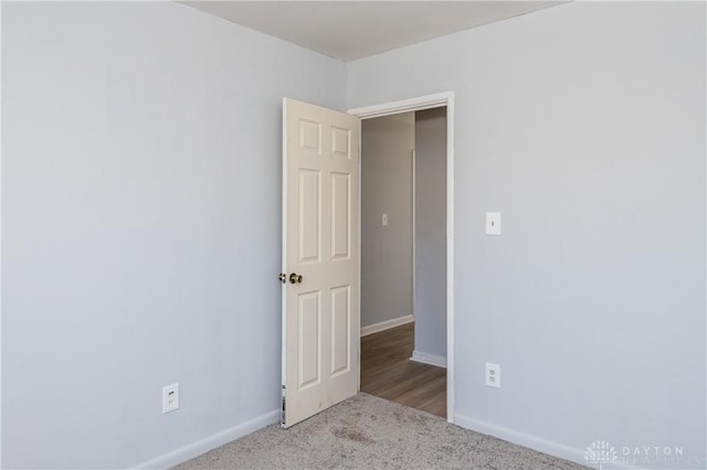 carpeted spare room with baseboards