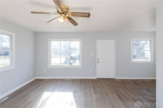 spare room with plenty of natural light, wood finished floors, and ceiling fan