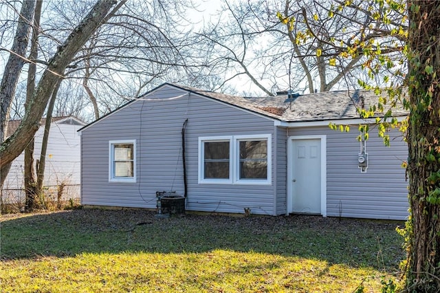 rear view of property with a lawn and central AC