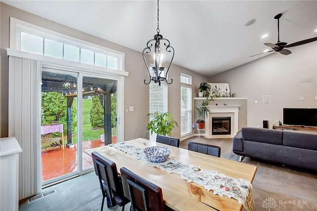 dining room with ceiling fan with notable chandelier, lofted ceiling, and carpet floors