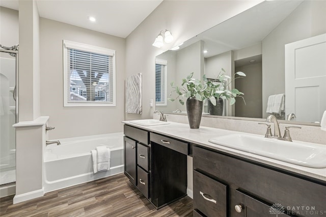 bathroom featuring vanity, wood-type flooring, and shower with separate bathtub