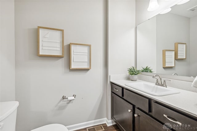 bathroom featuring hardwood / wood-style flooring, vanity, and toilet