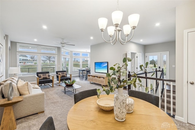 dining room with carpet flooring, ceiling fan with notable chandelier, and a healthy amount of sunlight