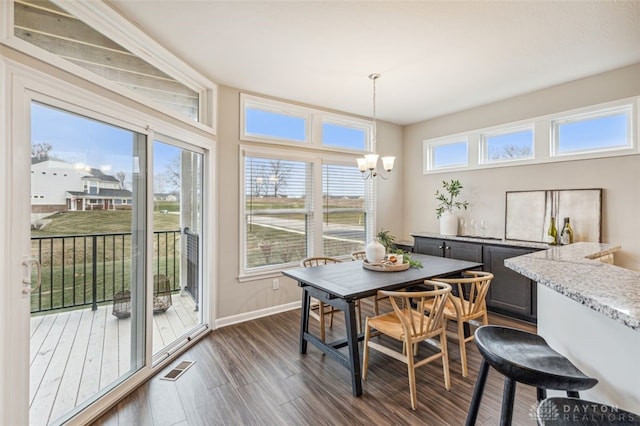 dining space with a notable chandelier and dark hardwood / wood-style floors