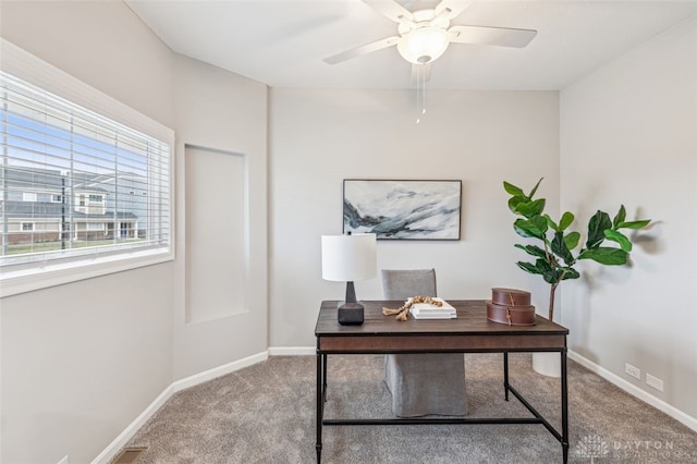 carpeted office space with ceiling fan