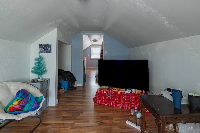 interior space featuring dark wood-type flooring, vaulted ceiling, and a textured ceiling