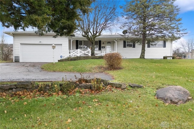 single story home with covered porch, a garage, and a front lawn