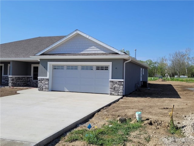 view of property exterior featuring a garage, cooling unit, concrete driveway, and stone siding