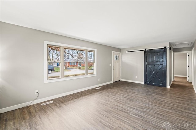 interior space featuring a barn door and dark wood-type flooring