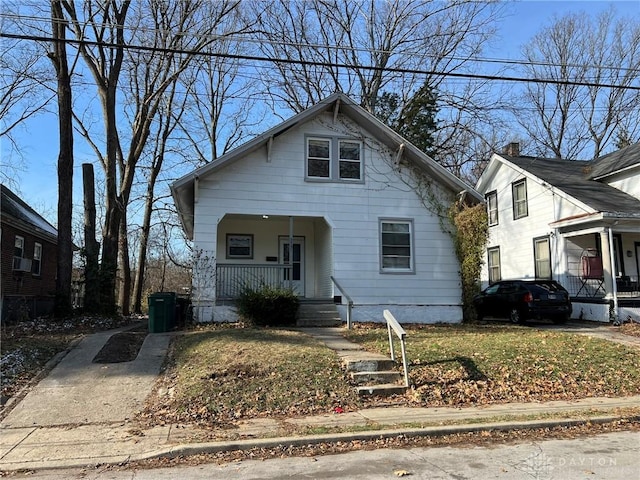 bungalow with a front lawn, cooling unit, and a porch