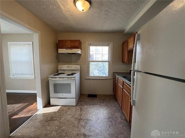 kitchen with a textured ceiling and white appliances