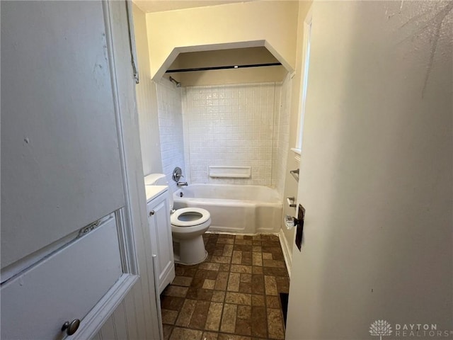 full bathroom featuring vanity, tiled shower / bath combo, and toilet