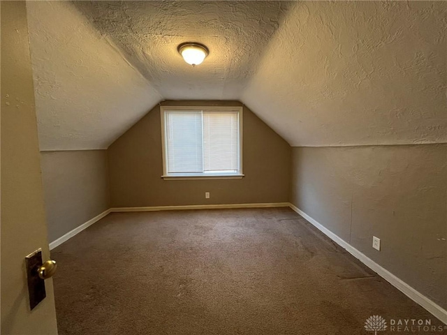 bonus room with carpet, a textured ceiling, and lofted ceiling