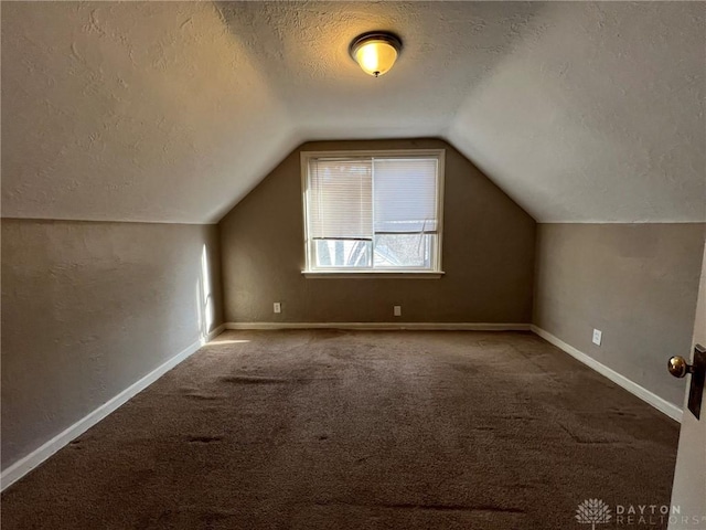 bonus room featuring carpet flooring, lofted ceiling, and a textured ceiling