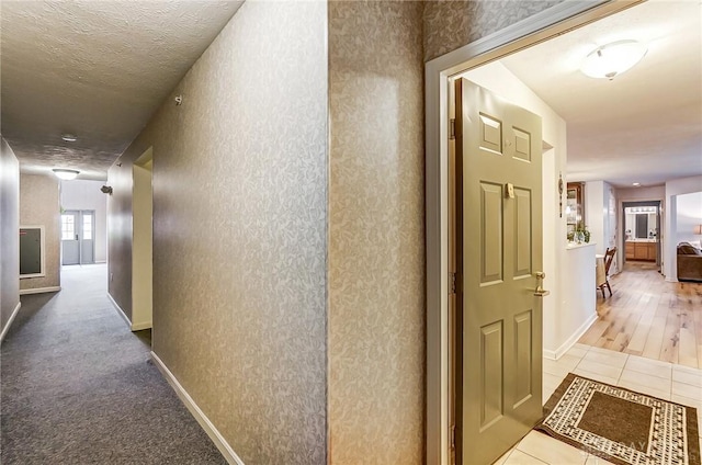 hall featuring a textured ceiling and light wood-type flooring