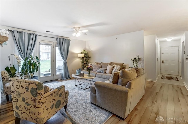 living room with ceiling fan and light hardwood / wood-style flooring