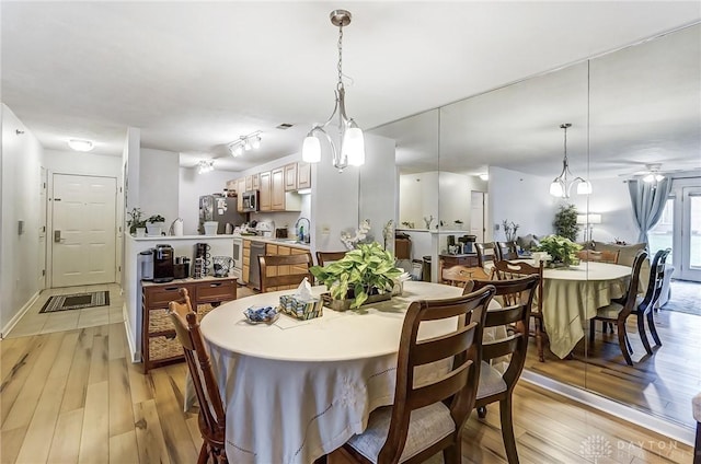 dining area featuring light wood-type flooring and sink