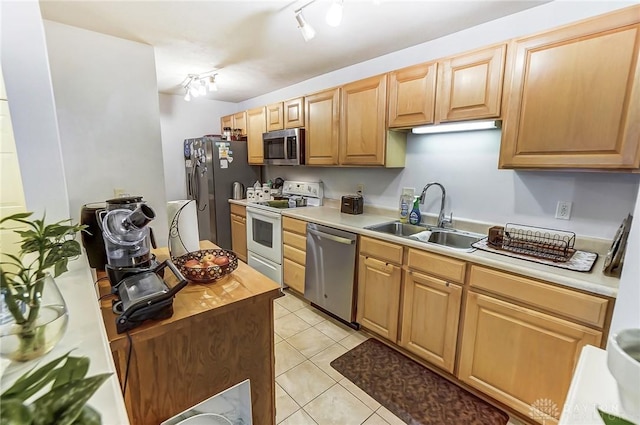 kitchen with light tile patterned flooring, stainless steel appliances, track lighting, and sink