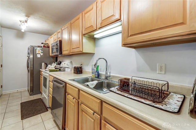 kitchen with light tile patterned flooring, sink, stainless steel appliances, and light brown cabinetry