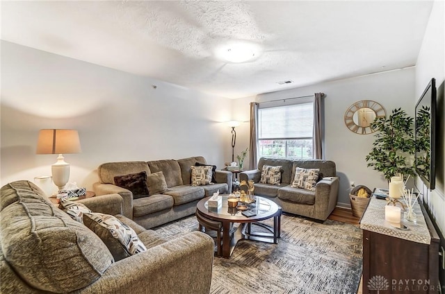 living room featuring a textured ceiling and hardwood / wood-style flooring