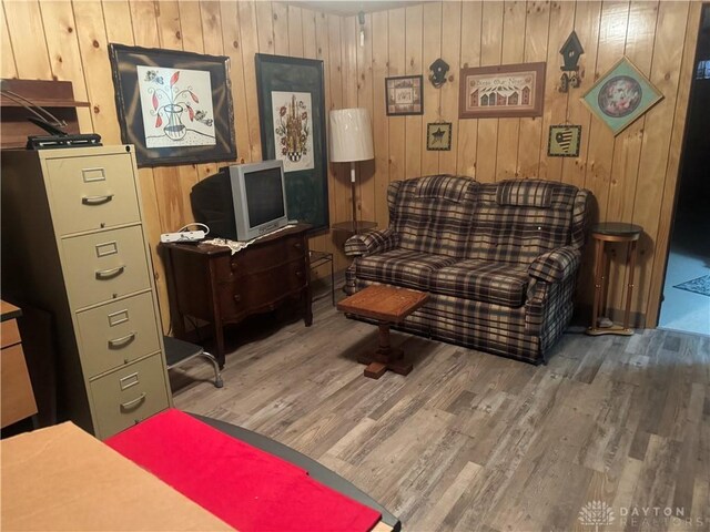 sitting room featuring hardwood / wood-style flooring and wood walls