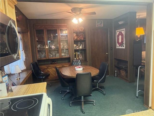 carpeted dining area with ceiling fan