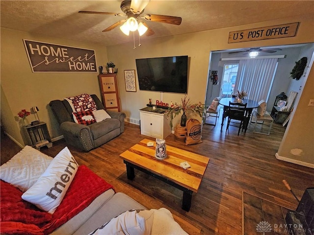 living room featuring wood-type flooring, a textured ceiling, and ceiling fan